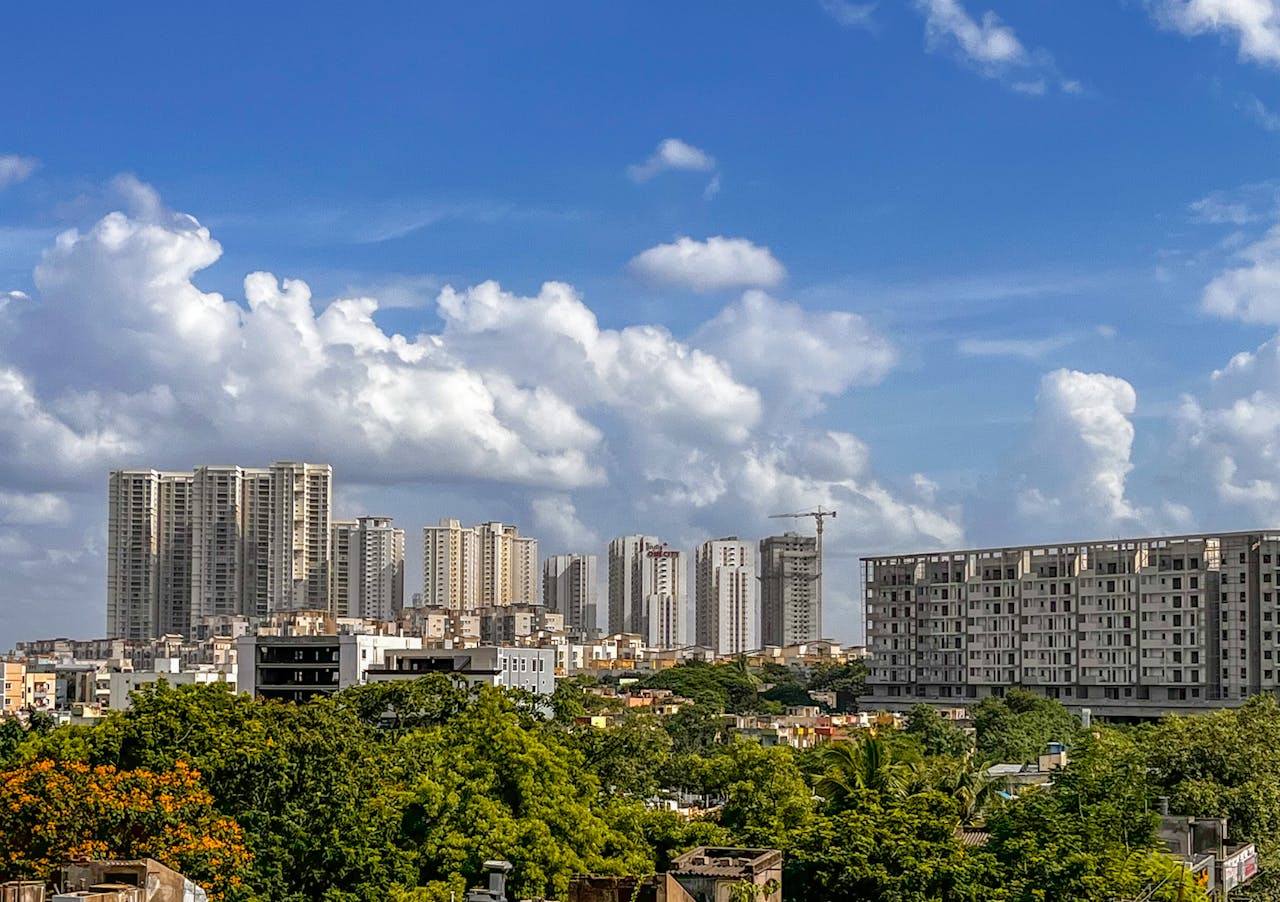 Stunning cityscape of Hyderabad's skyline with lush green foliage under a vibrant blue sky.