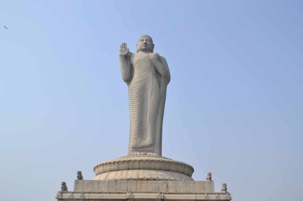 A majestic Buddha statue against a clear blue sky in Hyderabad, India.